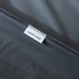 A close-up of a gray seam on the Linenly Luxe Cotton Sateen Fitted Sheet in Charcoal, featuring a white "SHORT SIDE" label—ideal for modern bedding made from long-staple cotton.